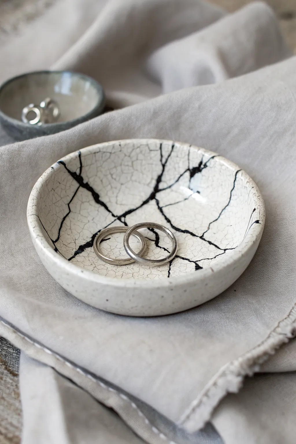 Bold crackle trinket dish with inky lines, holding rings for an effortless grunge touch.