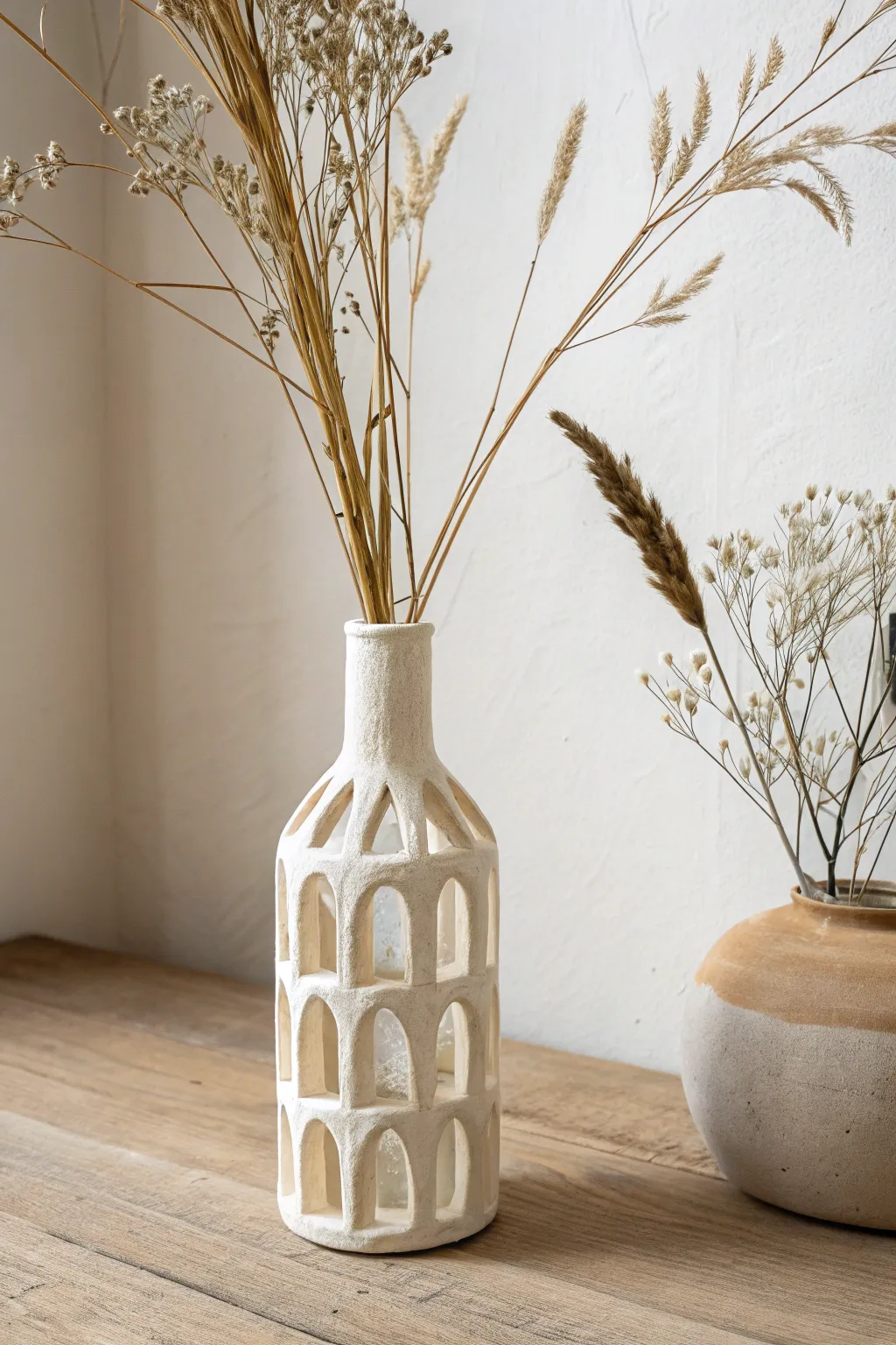 Minimal bud vase with an air dry clay cutout sleeve, warm neutrals and soft natural light