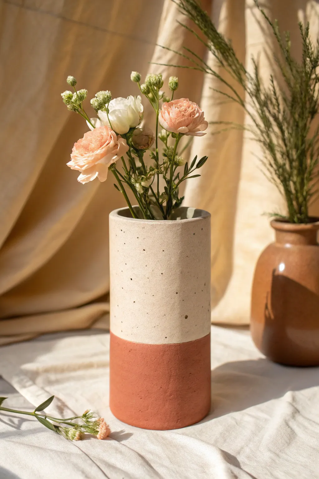 Half-dipped mud vase with a clean color block and bright blooms for effortless modern charm.