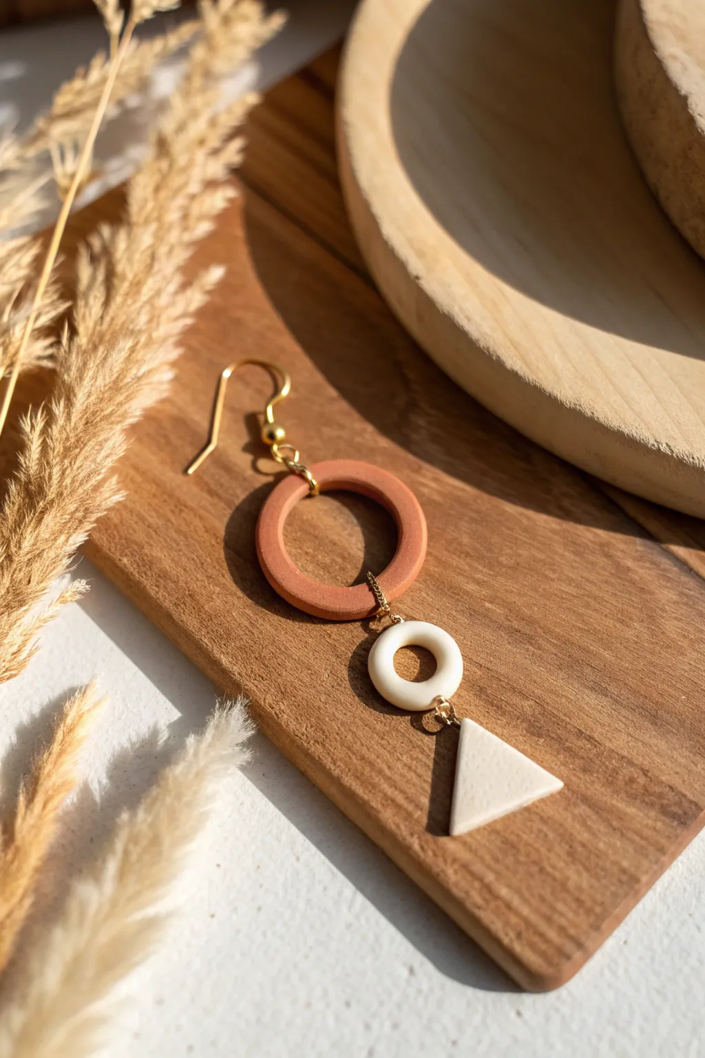 Minimal oven-bake clay hoop charm earring on warm wood, simple boho Scandinavian style.