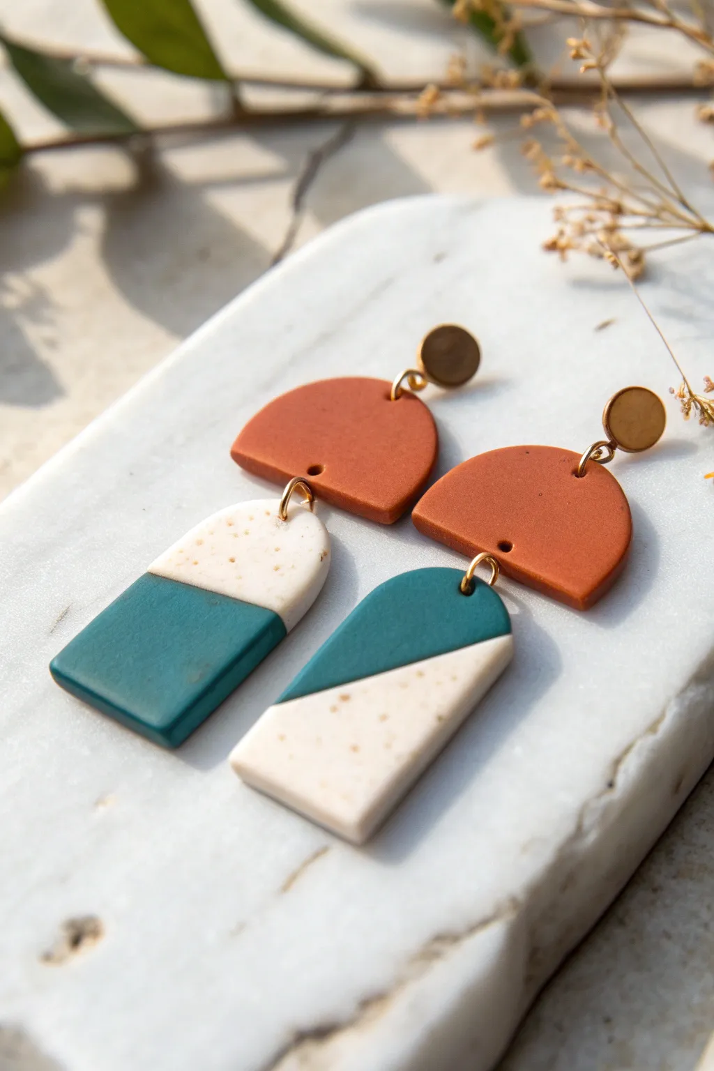 Bold color-block polymer clay earrings on pale marble, minimalist Scandinavian style with boho warmth