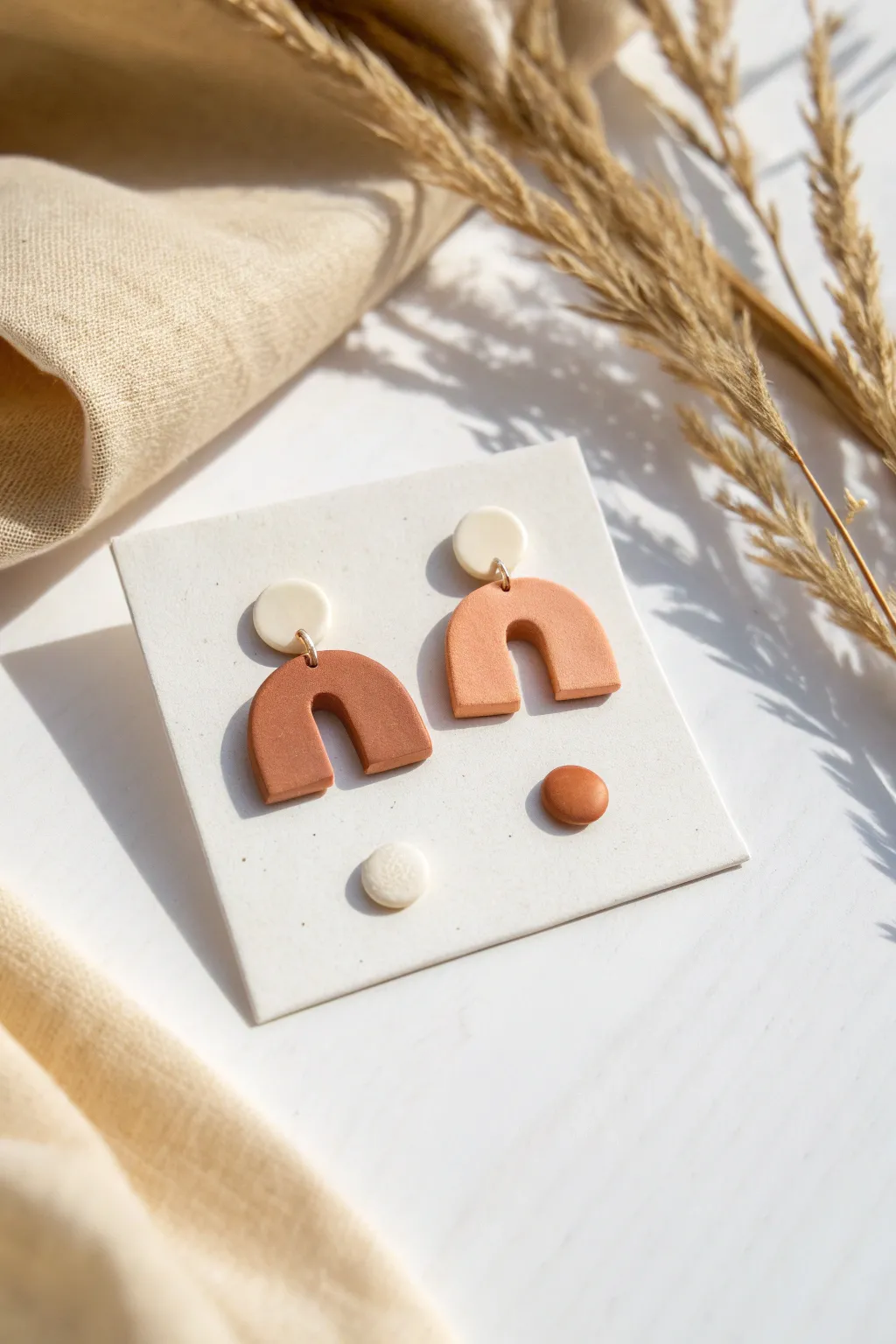 Simple air dry clay stud earrings in clean shapes, minimal and modern with warm earthy tones