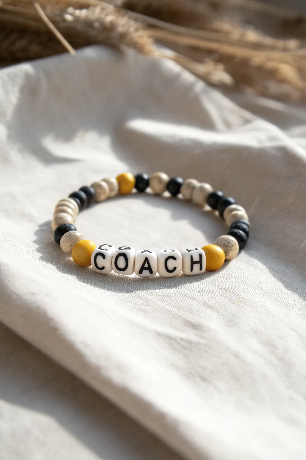 Sideline-ready coach bracelet in clean neutrals with bold black, white, and yellow clay beads