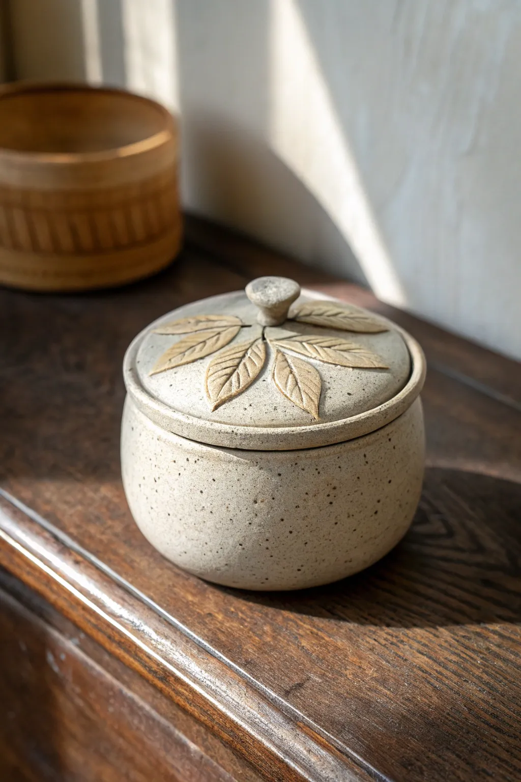 Mini lidded herb trinket jar with leaf detail, speckled clay, calm boho minimal style.