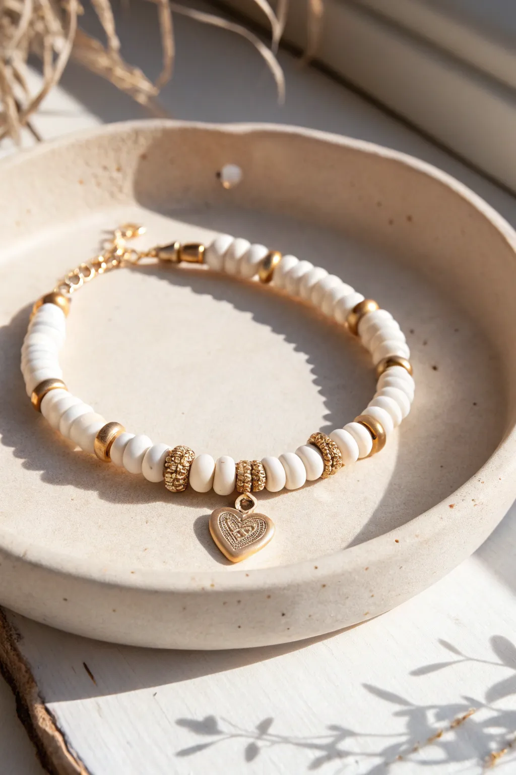 Dainty white clay disc bead bracelet with a single heart charm, minimalist and handmade.