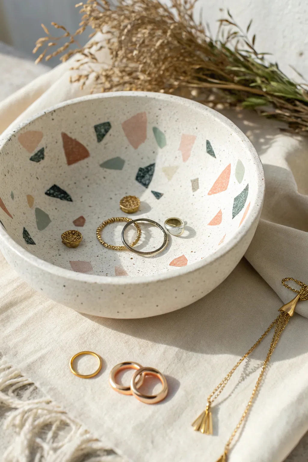 Minimal terrazzo air dry clay bowl with soft color chips, styled with rings for simple scale