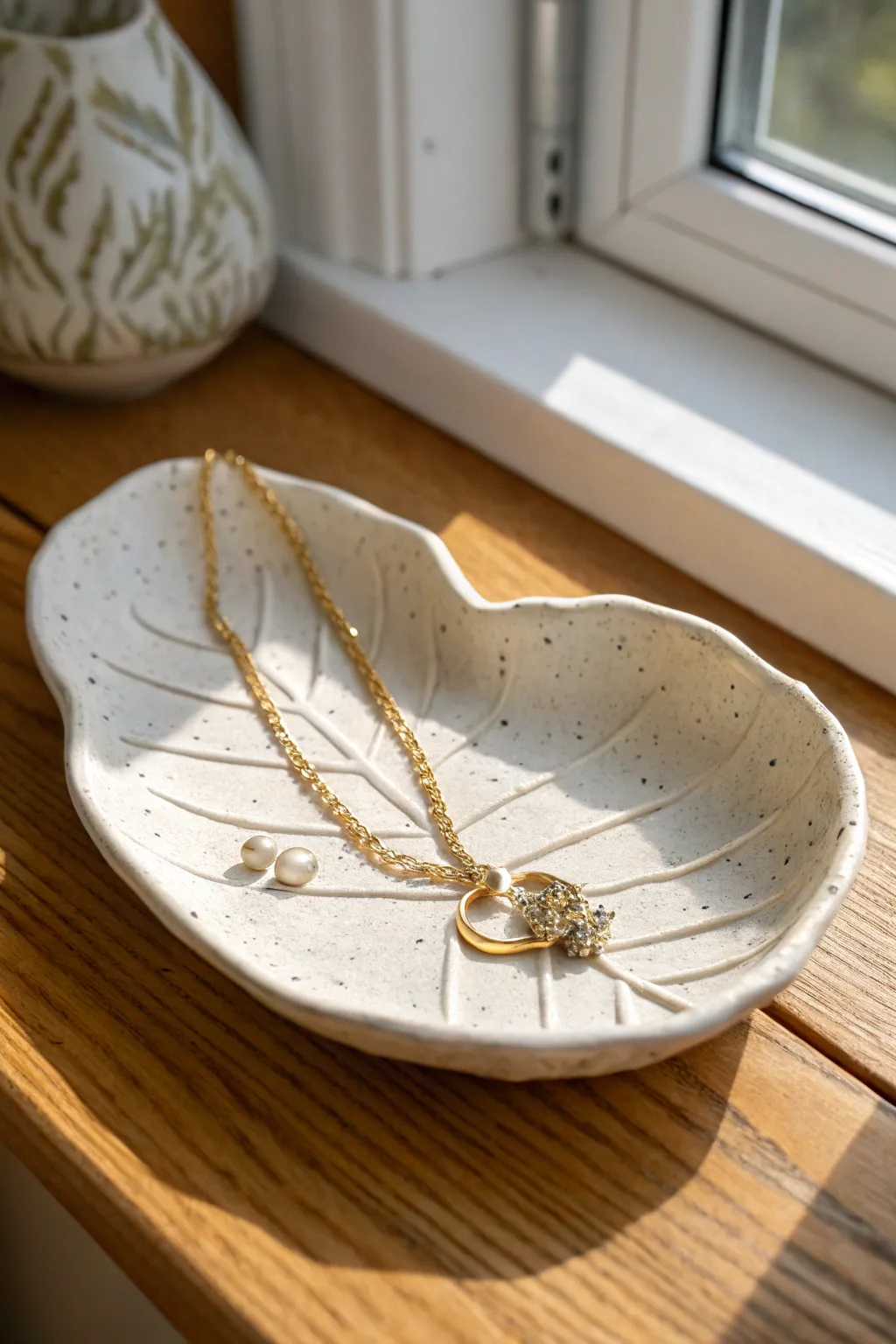 Leaf-shaped air dry clay tray with a delicate necklace, simple, cozy, and beautifully minimalist.