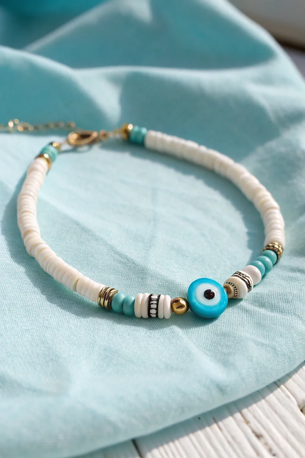Beachy heishi bracelet with a centered evil eye bead for effortless vacation vibes.