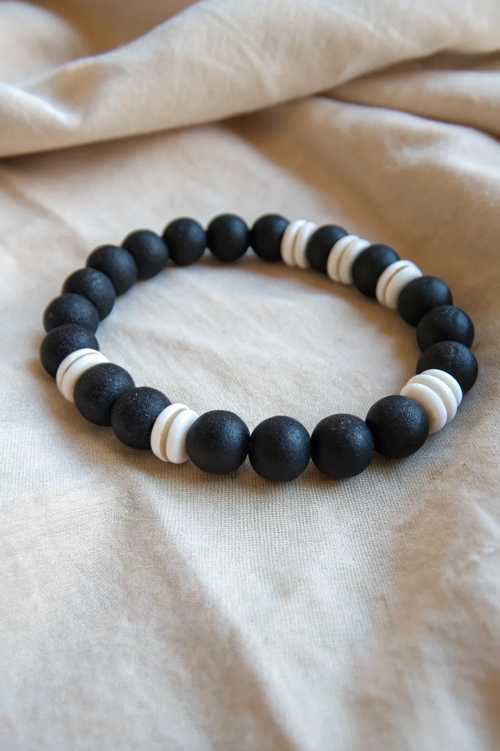 Symmetrical black-white-black clay bead bracelet with a crisp center stripe and minimalist contrast