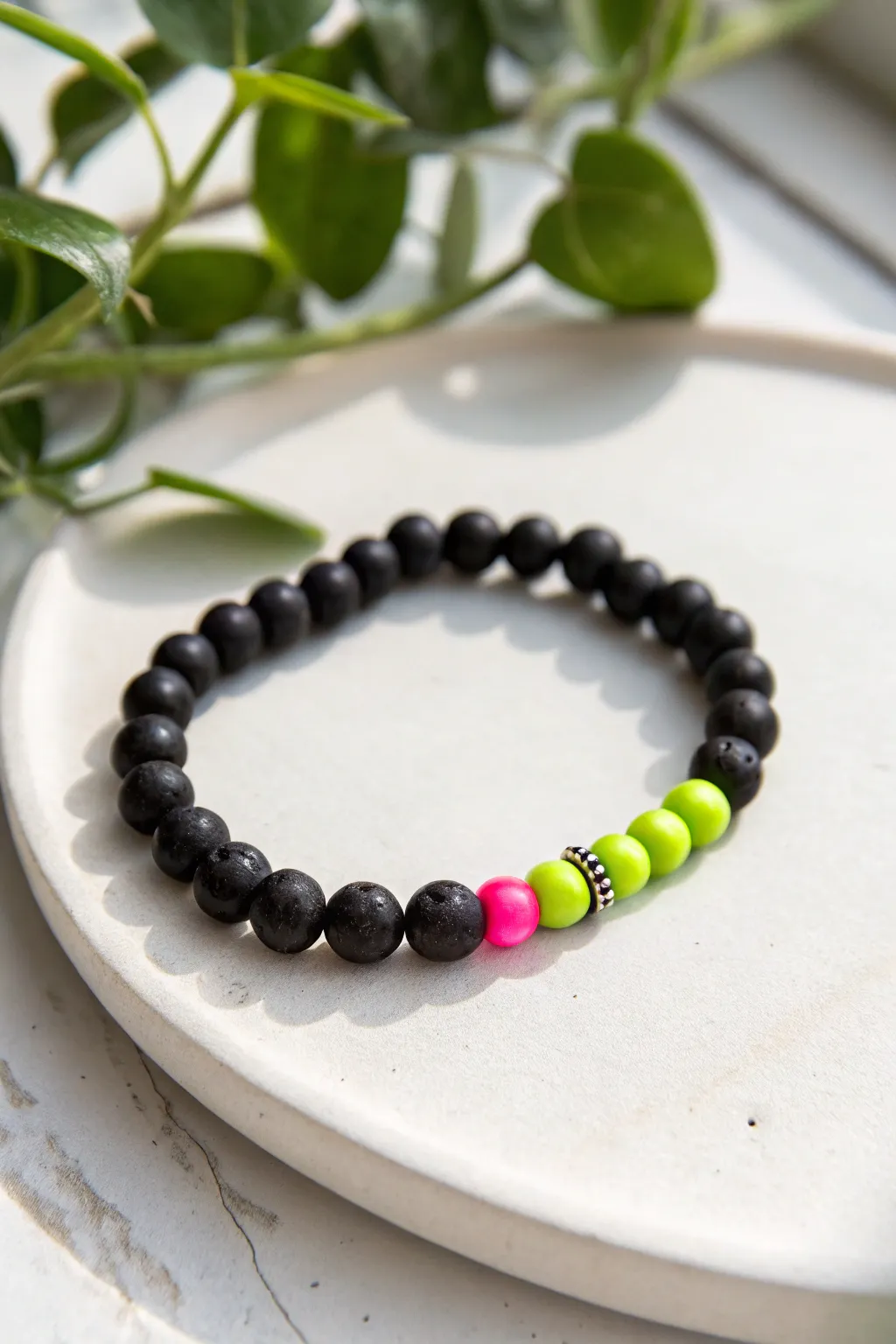 Matte black clay bead bracelet with neon lime and hot pink color blocks on crisp white