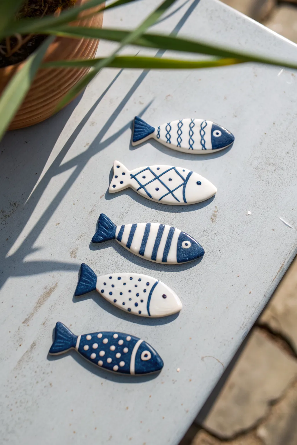 Minimal blue fish clay magnets with crisp white details on matte metal, simple and charming