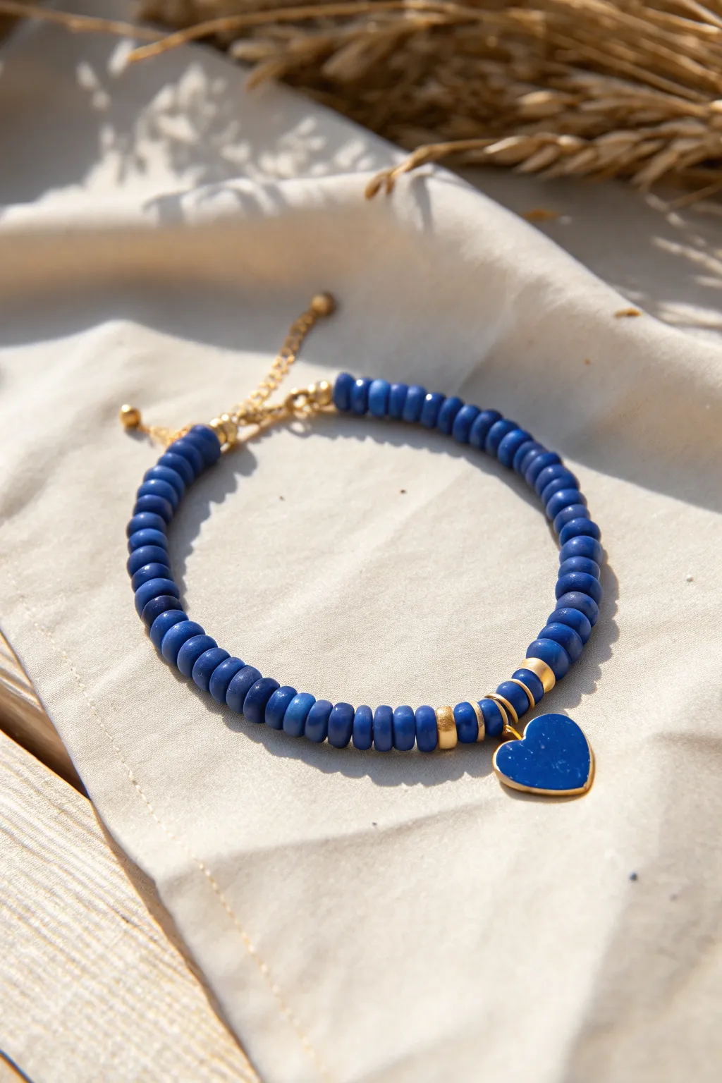 Preppy blue heishi bracelet with a glossy heart centerpiece and navy-baby blue contrast.