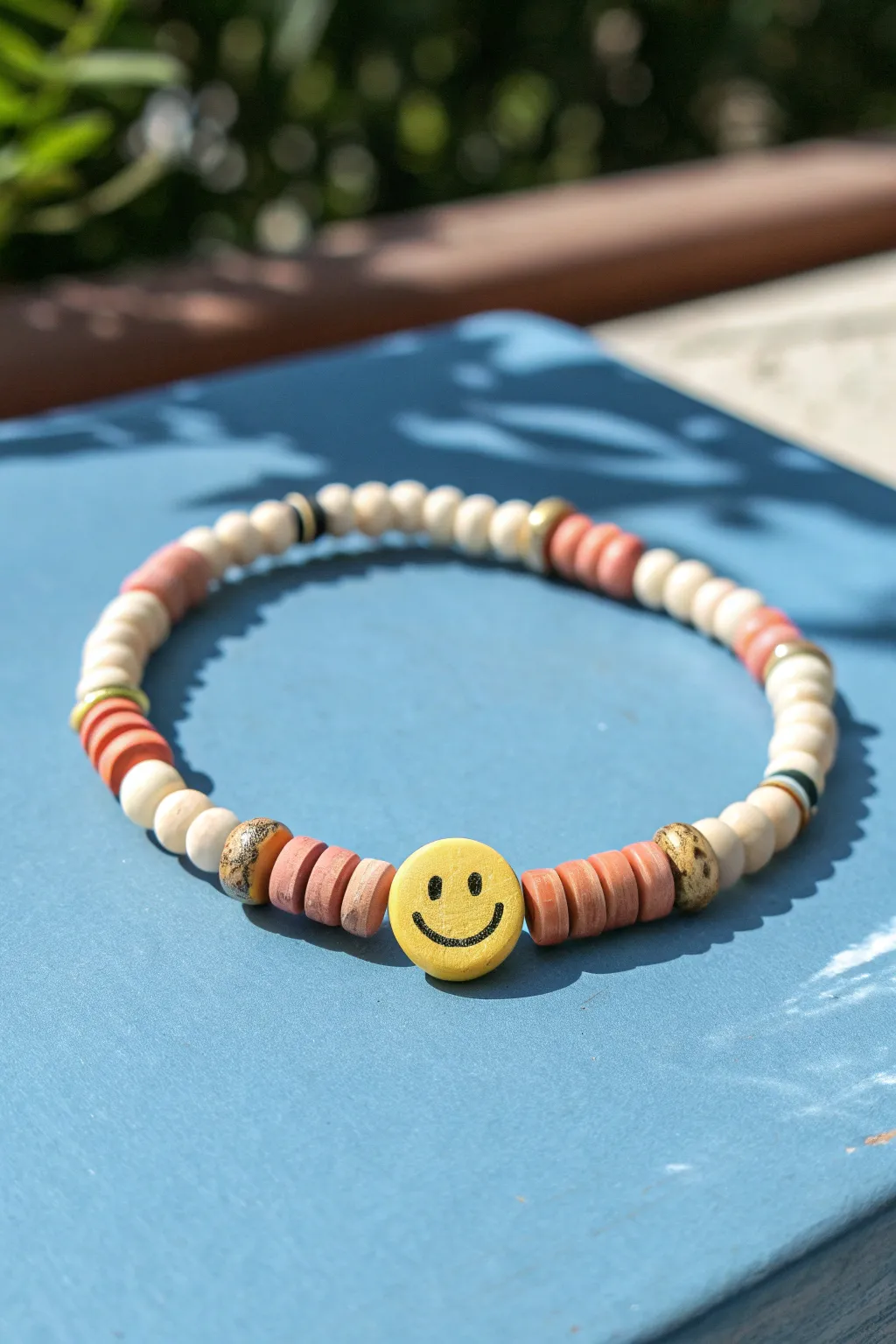 A cheerful smiley focal bead pops against bold color, framed by simple handmade clay discs.