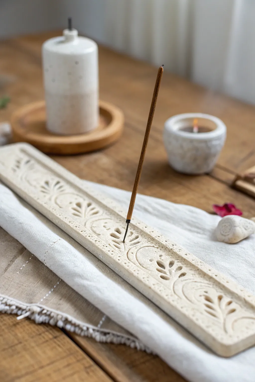 Minimal groove-carved clay incense holder on an oak tray, calm spa styling and natural texture