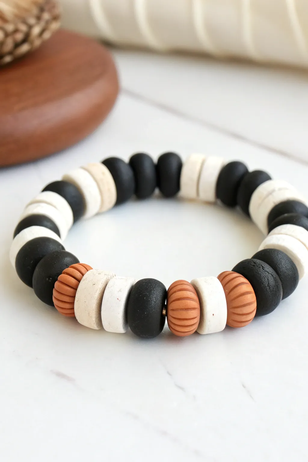 Bold black and white clay discs with a warm center accent for a crisp graphic look.