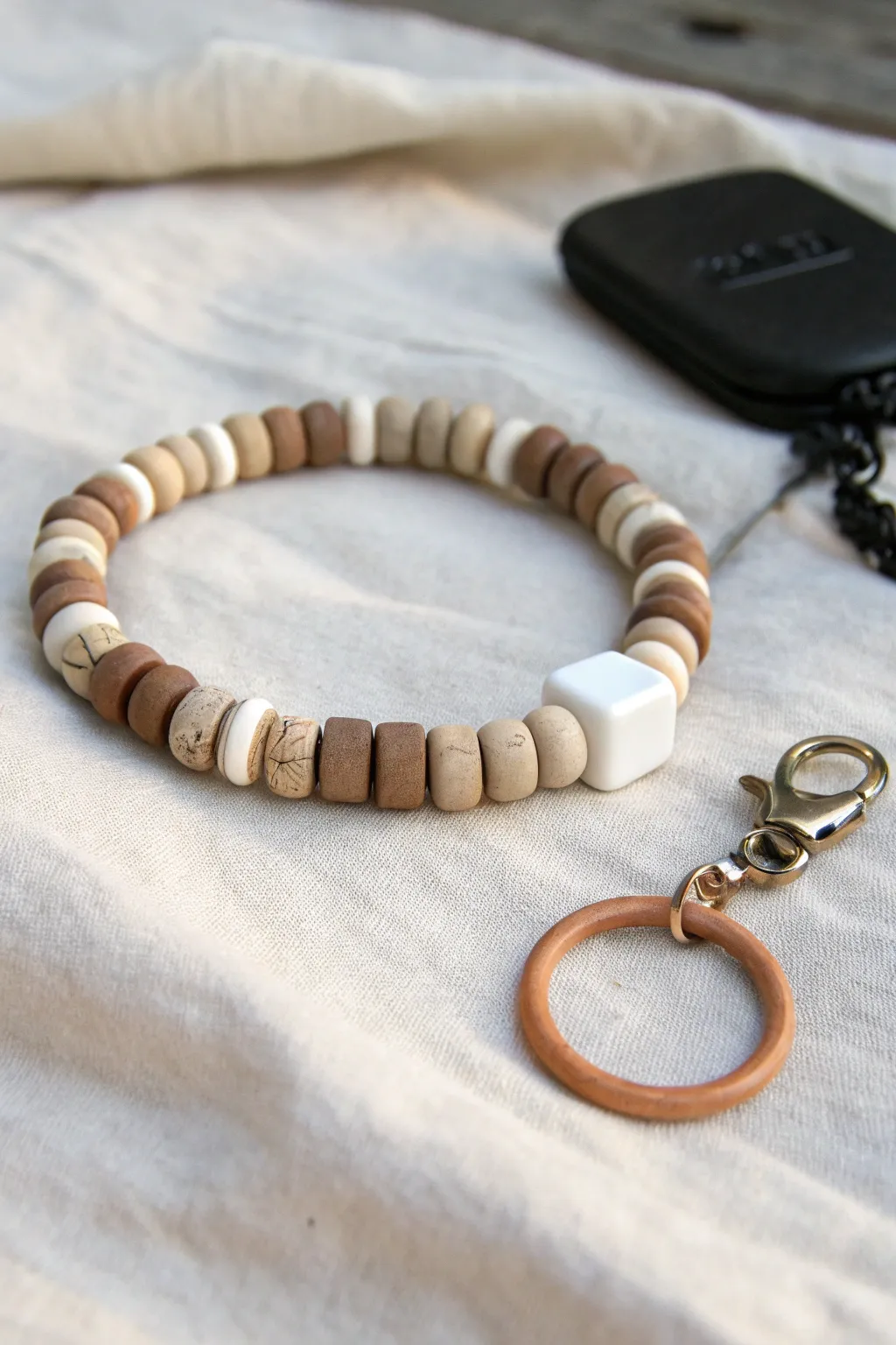 Neutral clay disks with one centered initial bead for a clean, everyday bracelet idea for guys