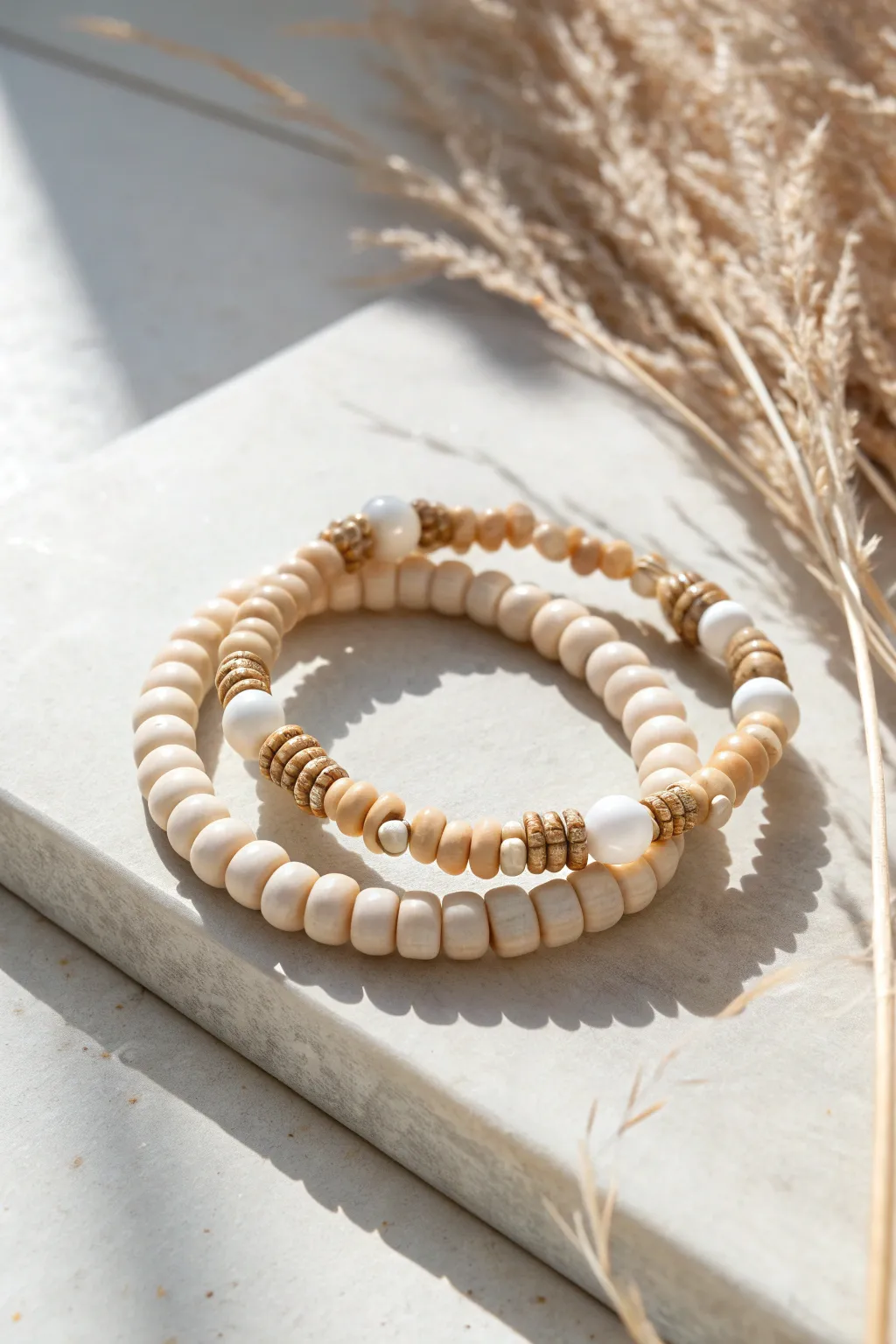 Neutral heishi clay beads with pearl accents make a soft, modern bracelet stack for everyday wear.