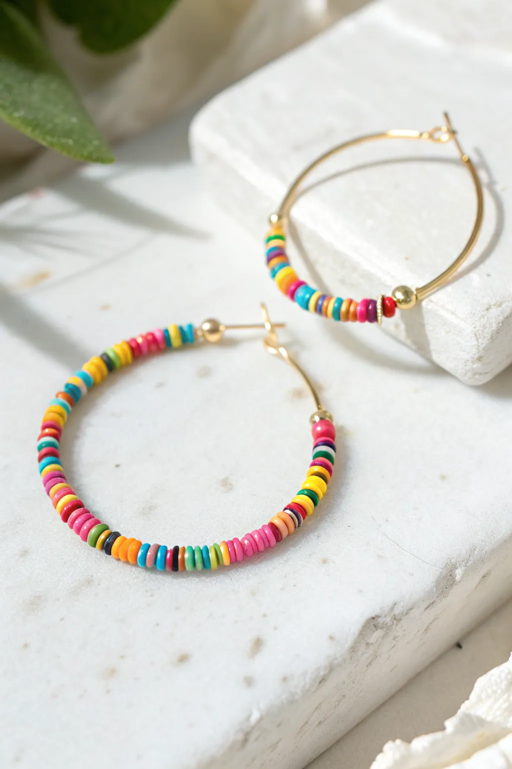 Confetti heishi clay bead hoop earring with playful random colors on crisp white, minimalist style