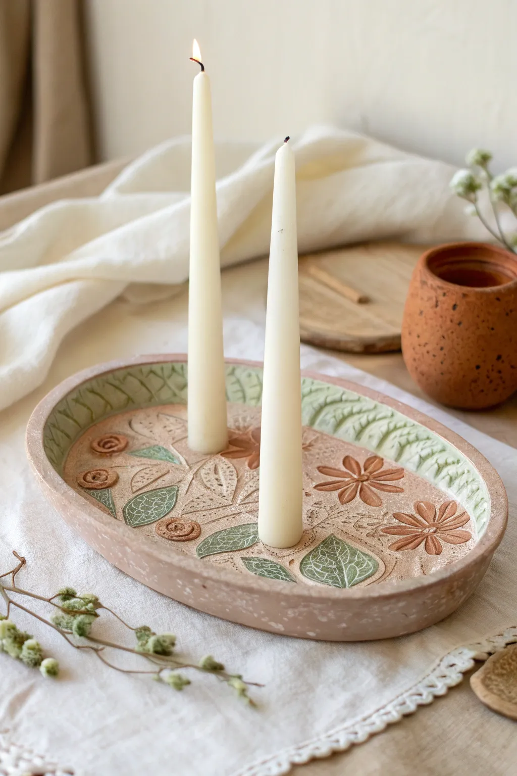 Floral-stamped oval clay tray with two tapers, minimalist boho charm for cozy evenings.