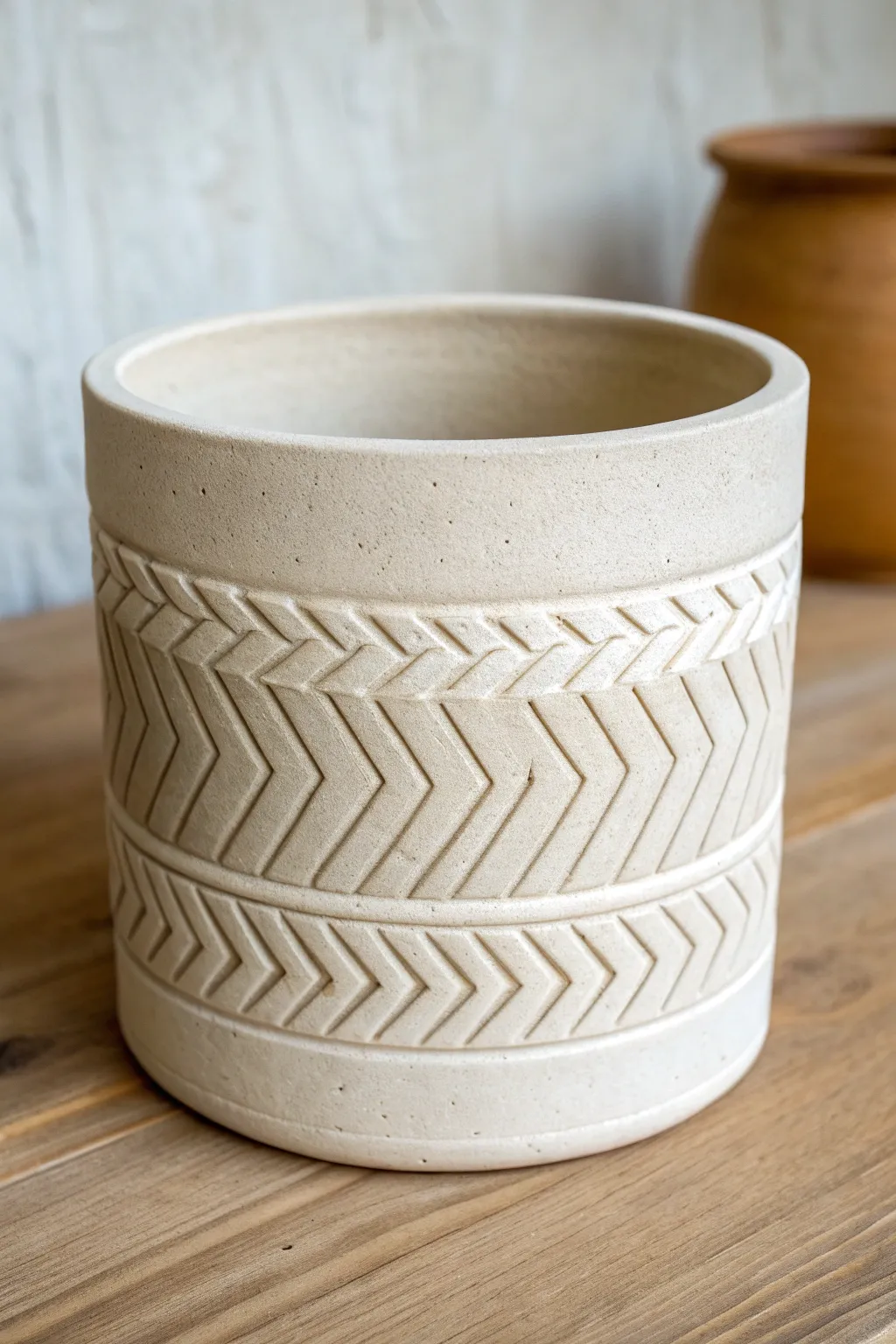 Bold chevron carving on a minimalist planter, graphic grooves with a warm handmade feel