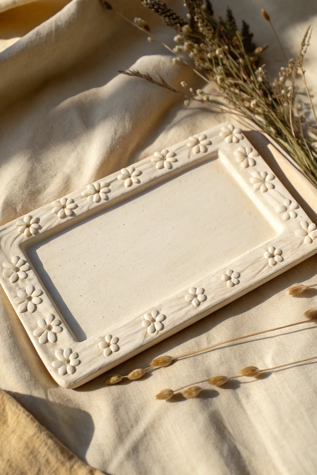 Soft floral relief border frames a clean center, a minimalist clay name plate idea in neutral tones.