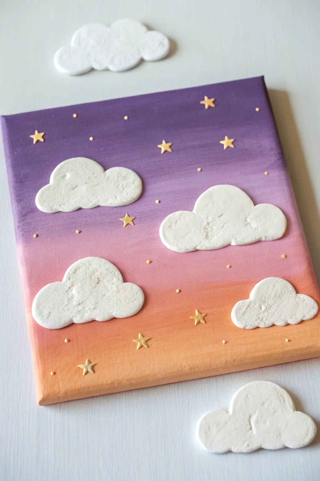 Dreamy ombre sunset canvas with raised clay clouds and tiny star dots, minimalist and cozy.