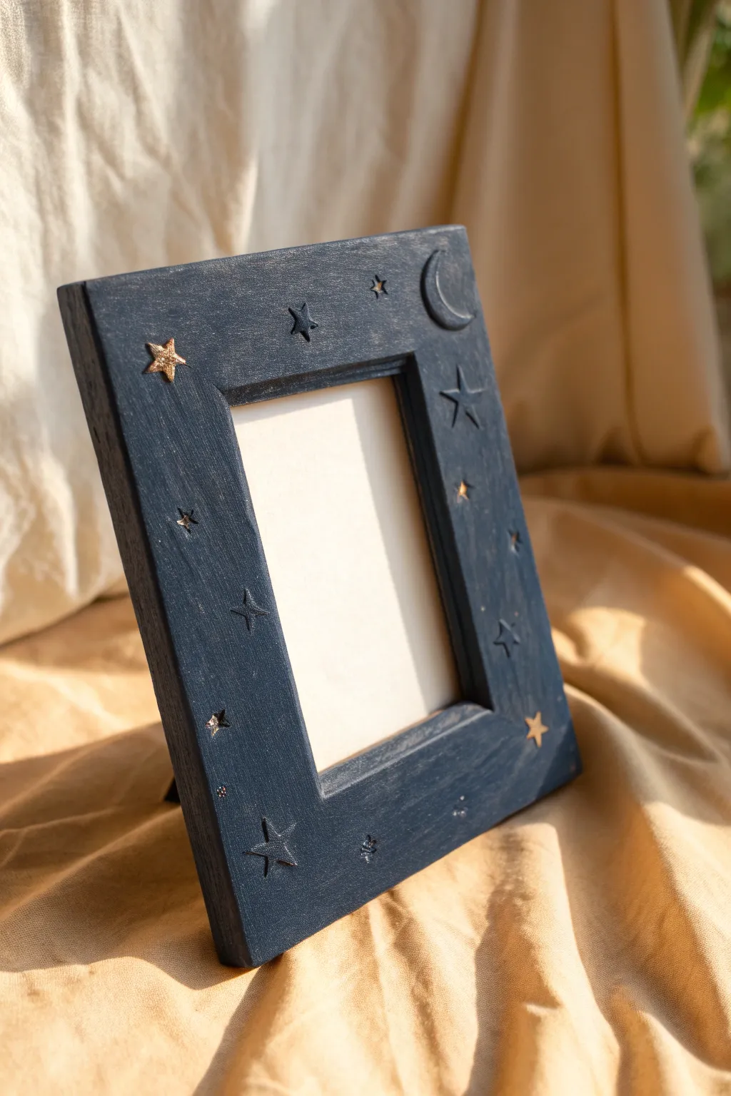 Midnight clay frame with raised stars and a crescent moon, simple, moody, and handmade.