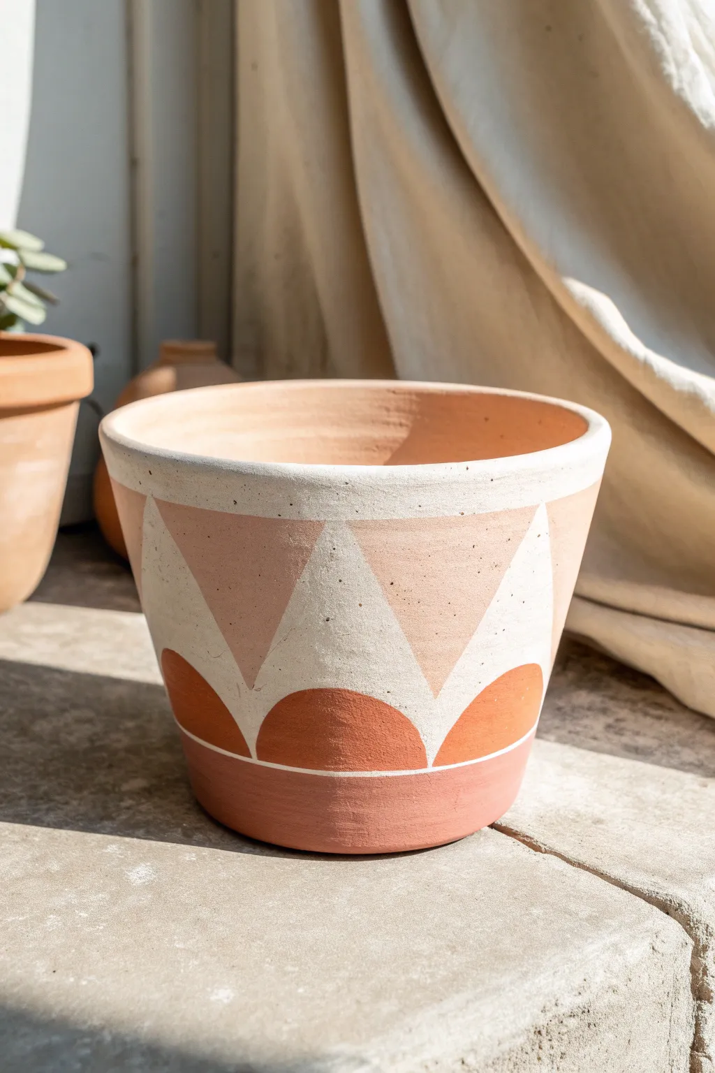 Modern color block clay pot with arches and triangles in neutrals with a blush pop
