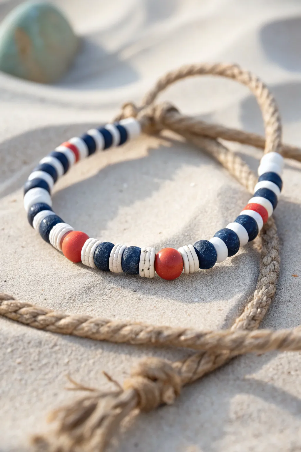Navy, white, and a pop of red bring crisp nautical charm to this beachy clay bead bracelet.