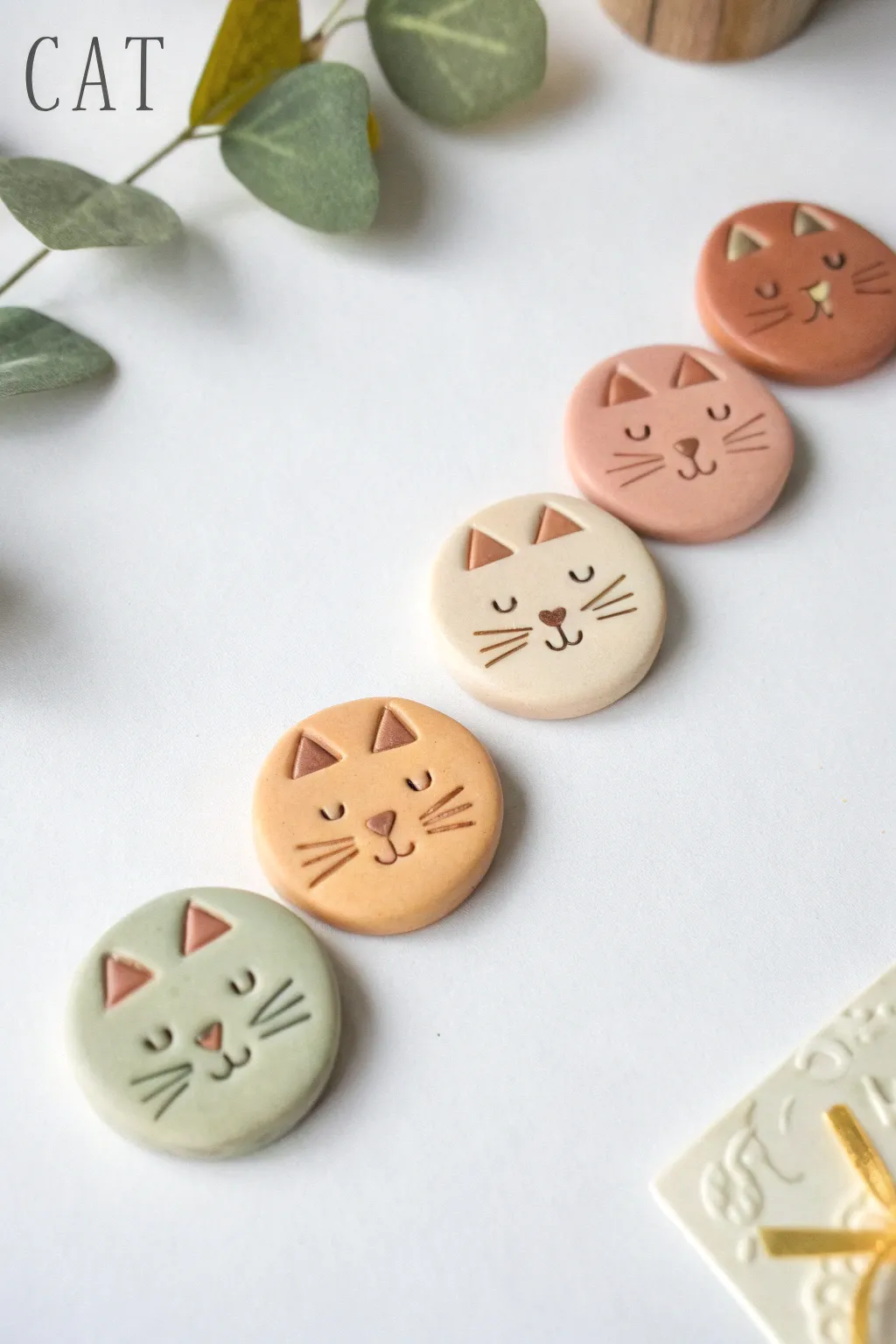 Minimal clay cat face magnets in soft earthy tones, a cute and simple DIY set to try.