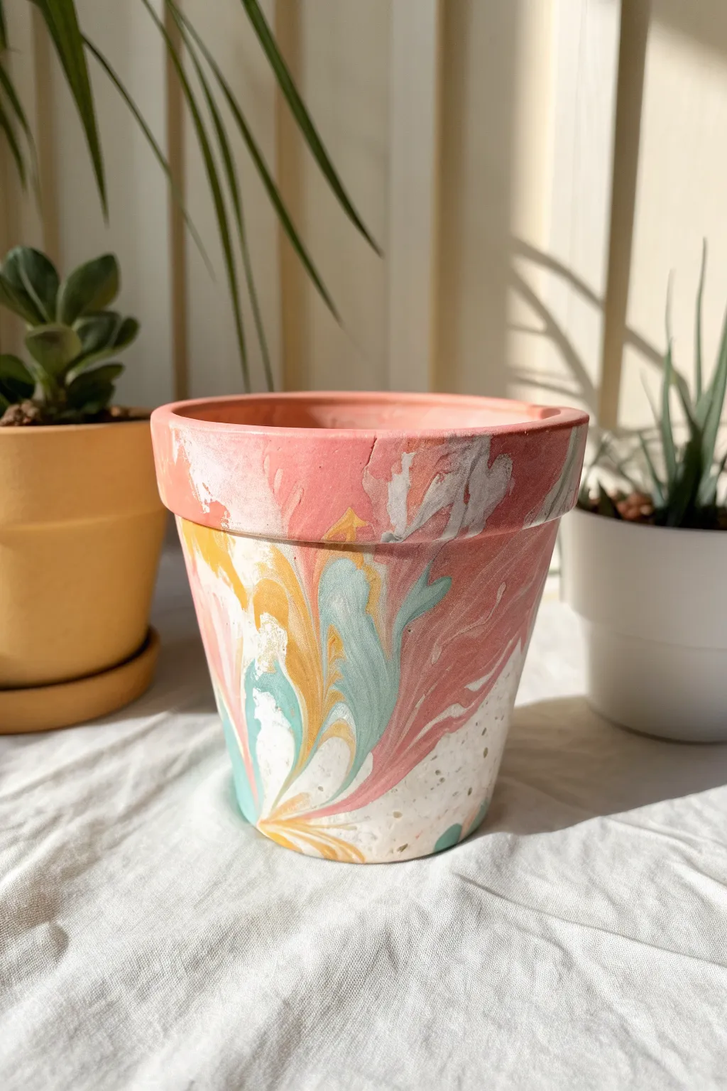 Bright pour-painted clay pot with glossy drips and soft Scandinavian styling, messy-pretty perfection