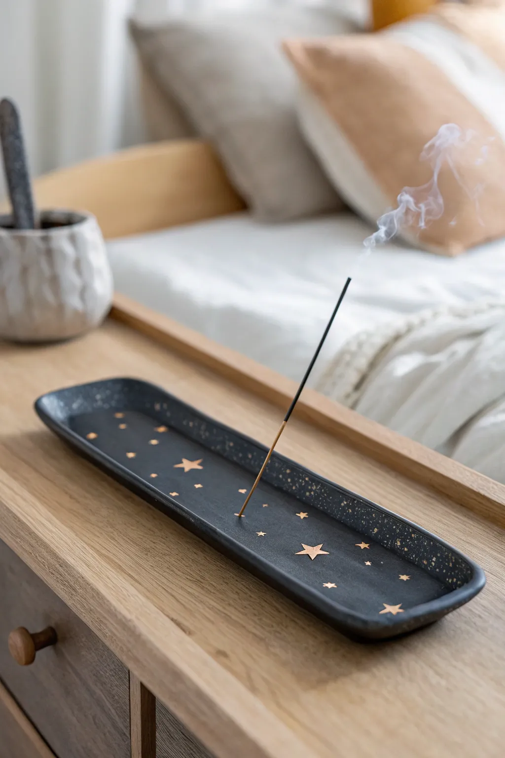 Starry air-dry clay incense tray in matte charcoal, a calm minimalist bedside accent