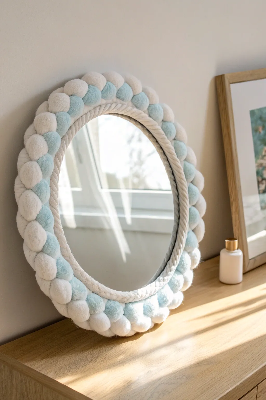 Puffy foam clay cloud halo mirror with soft blue shading on a bright oak tabletop