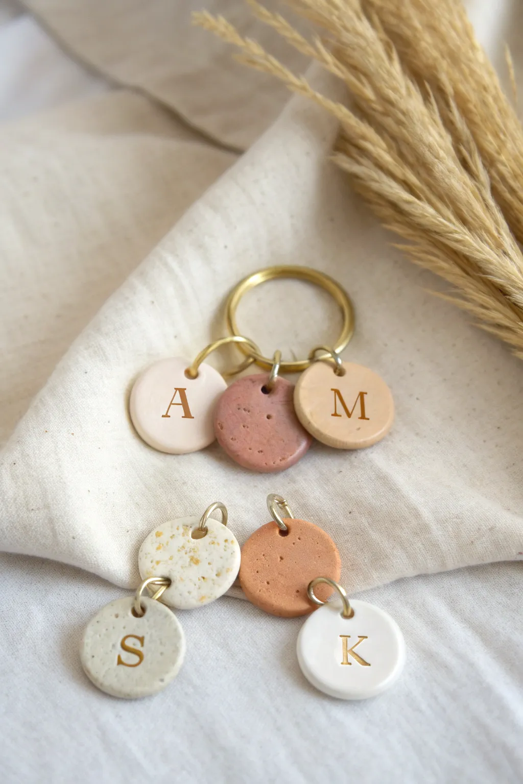 Minimal polymer clay initial charms on a brass ring, Scandinavian calm with boho warmth.