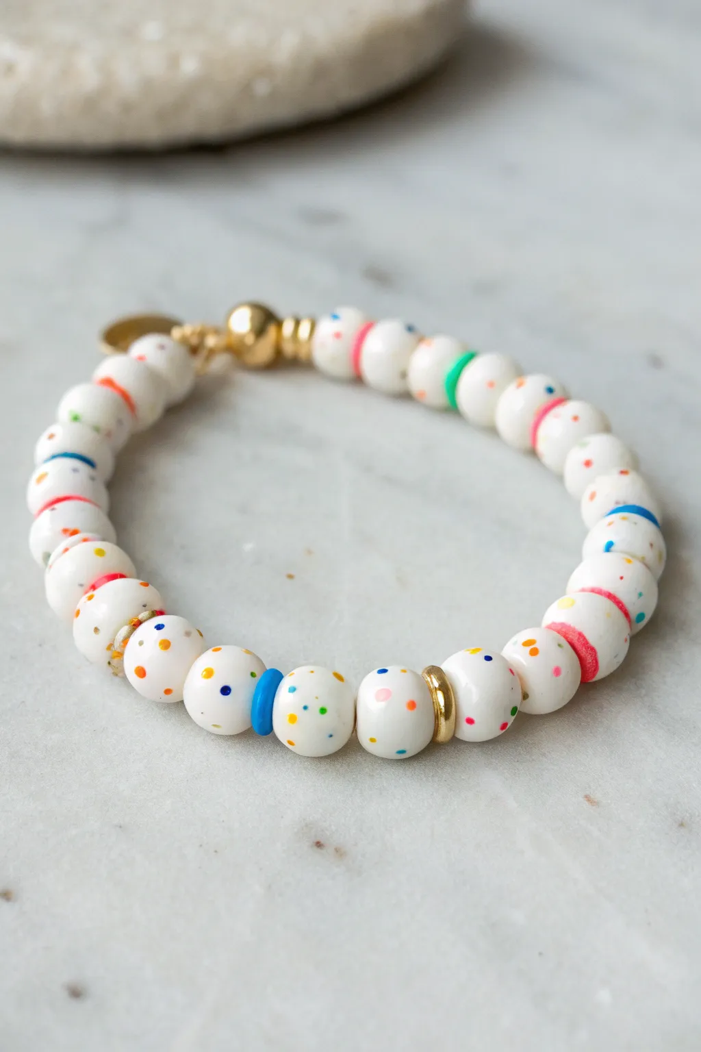 White heishi bead bracelet with confetti pops and gold spacers for a crisp preppy vibe.