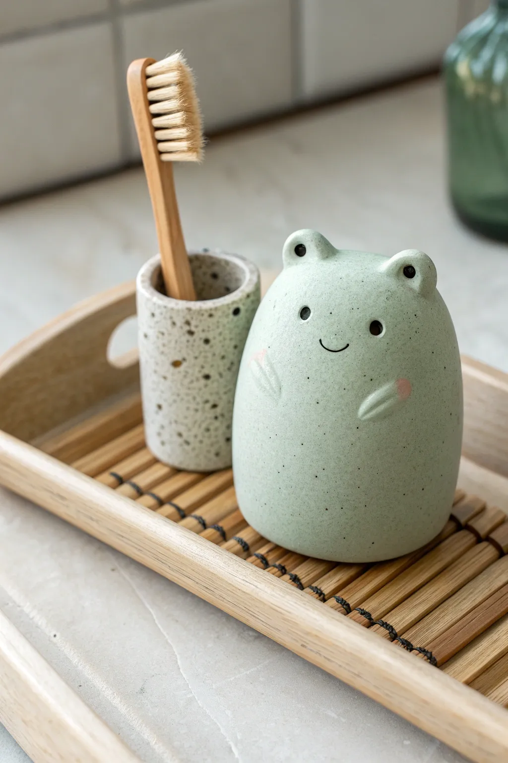 Soft clay blob critter toothbrush holder in calm sage tones, minimal, cute, and handmade.