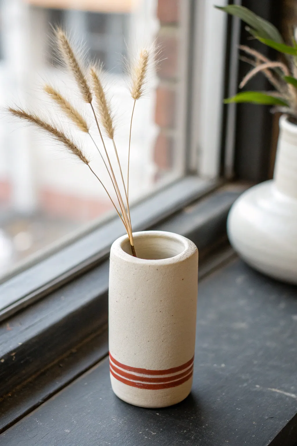 Tiny air dry clay magnetic bud vase, minimalist with a boho touch, styled with a dried stem.