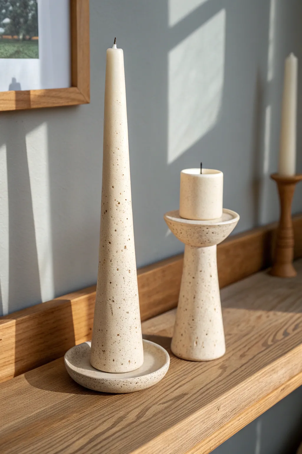 Minimalist clay taper holders, tall and short, styled in warm light for a cozy Nordic shelf.