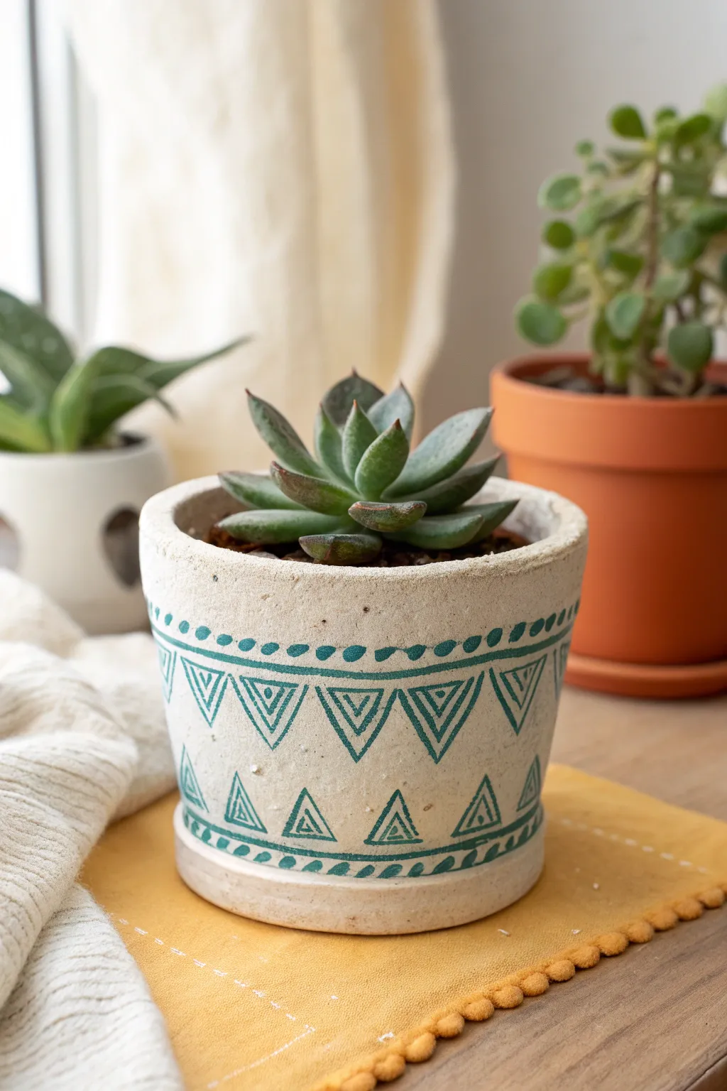 Easy stamped air dry clay pot with painted highlights, perfect for a tiny succulent on a bold surface.