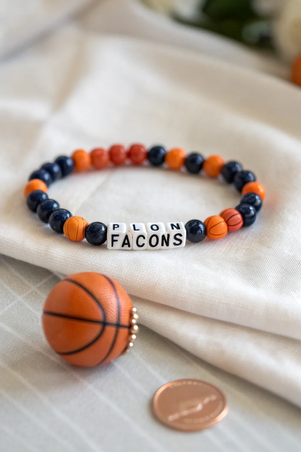 School color clay bead bracelet with mascot letters and tiny basketball charm, clean boho vibe.