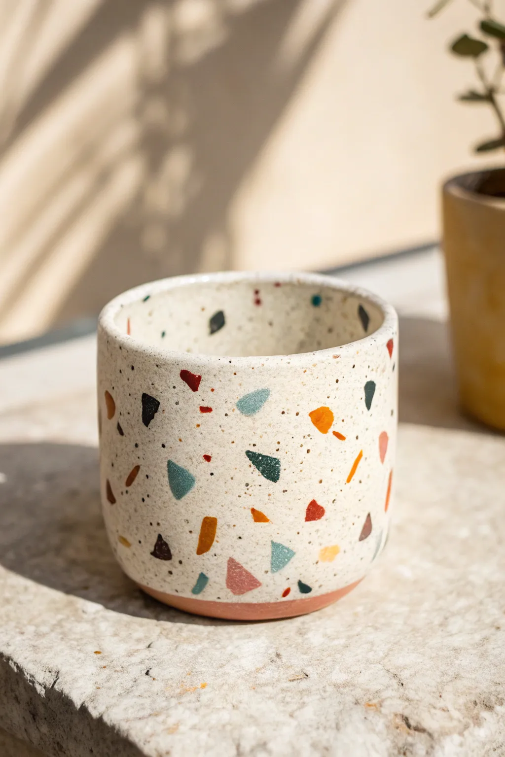 Terrazzo-speckled ceramic cup in bold colors, bright natural light, minimalist boho charm.