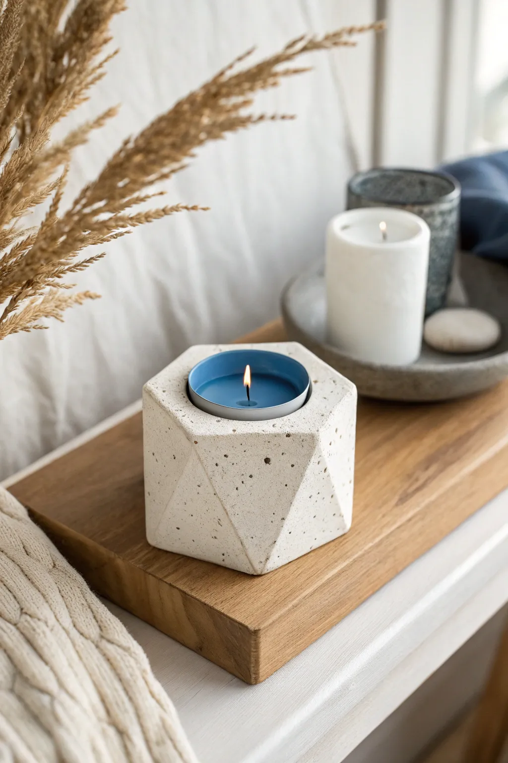 Simple handmade clay candle holder with a bold taper candle for a cozy minimalist shelf moment.