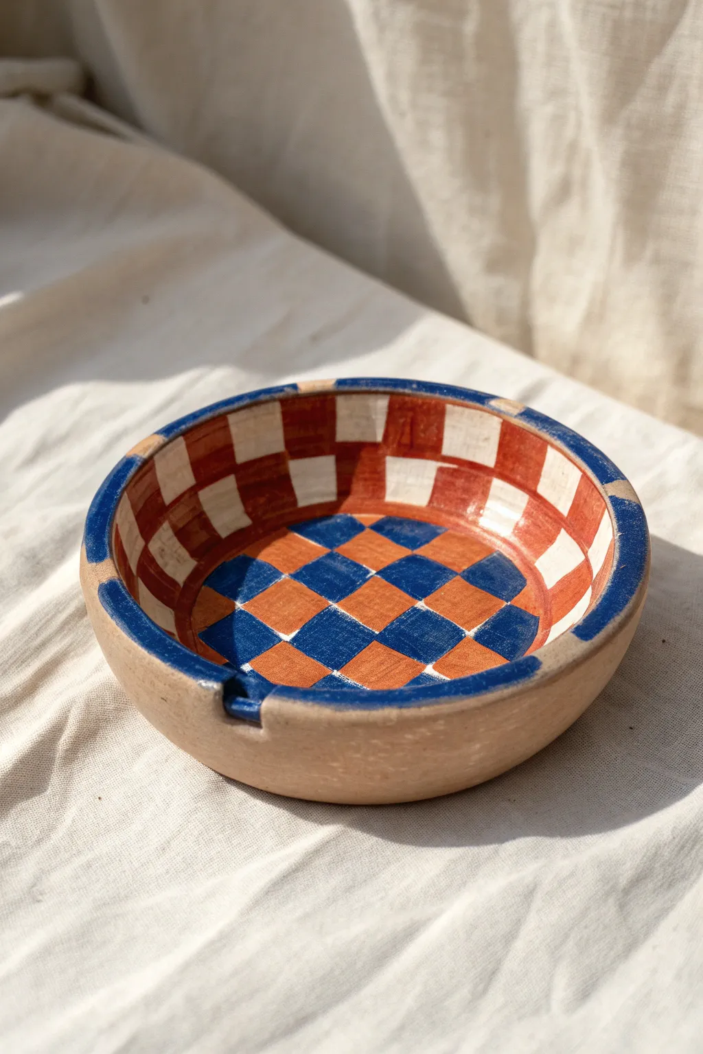 Bold checkerboard clay ashtray with simple notches, minimalist shape, and indie-kid color pop.