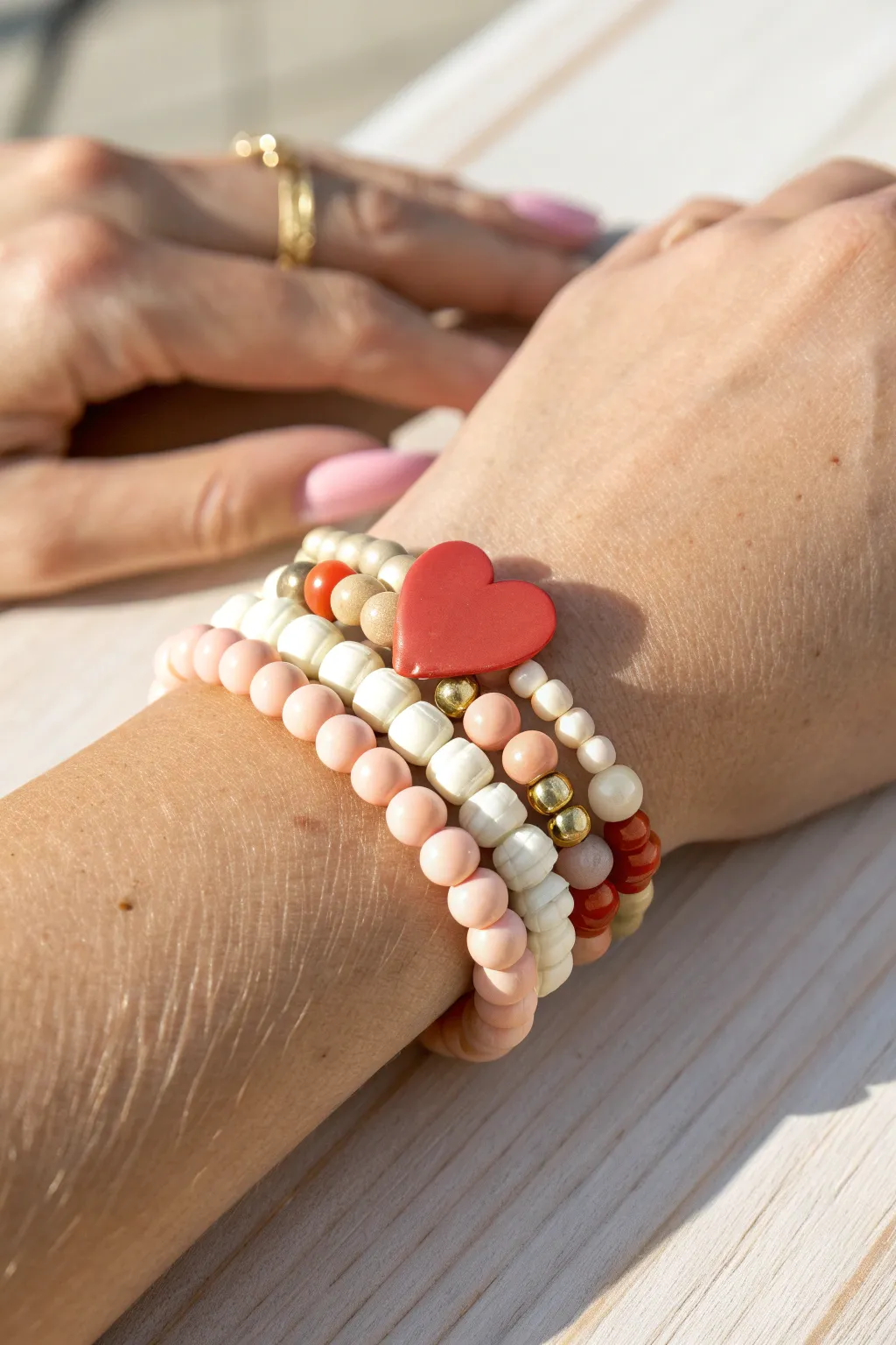 One bold heart charm clay bracelet centered in a simple stack of calm, minimal supporting strands
