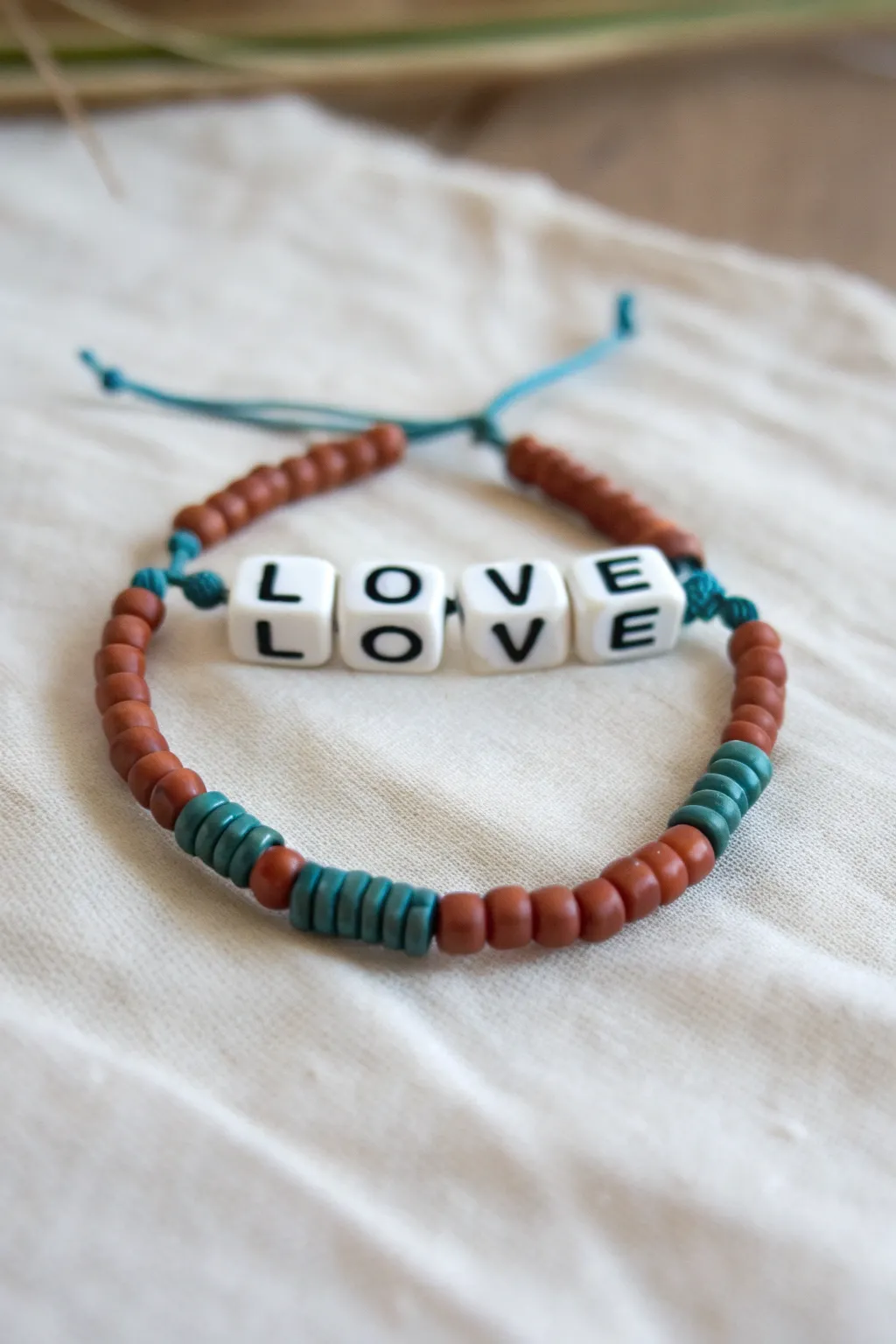 Bold heishi clay bracelet with a crisp LOVE letter-bead centerpiece, minimalist and boho-chic
