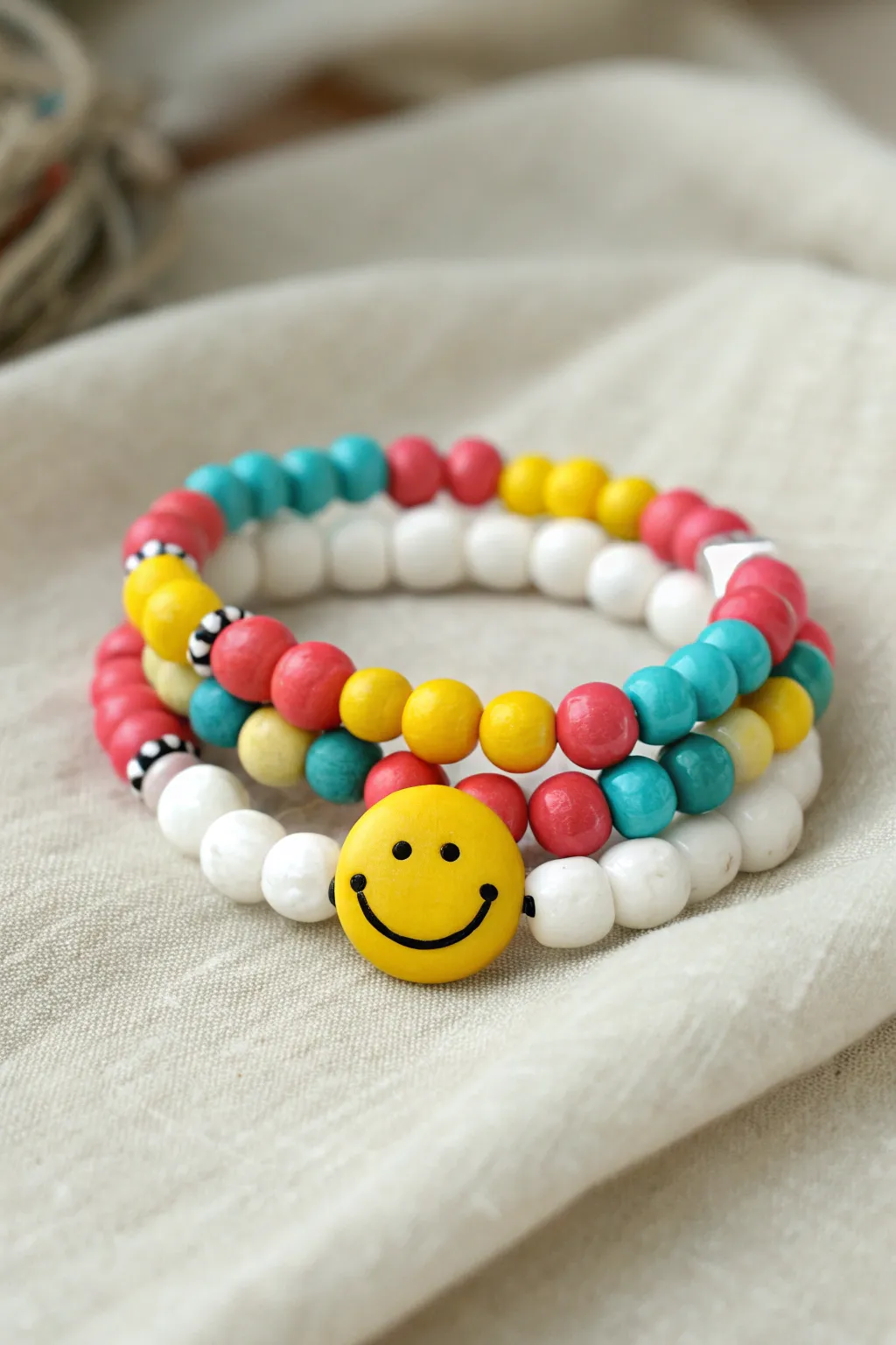 Bright clay bead bracelet stack with a simple smiley centerpiece for cheerful minimalist style.