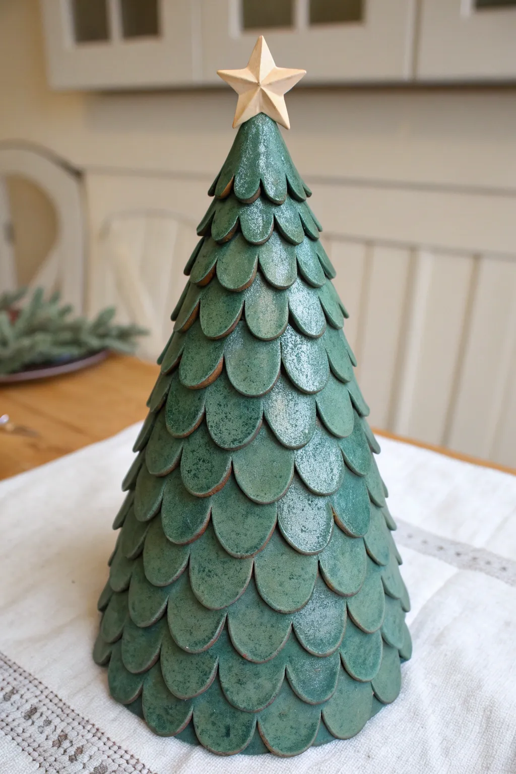 Scalloped clay Christmas tree with a tiny star topper, minimalist Nordic-boho holiday decor.