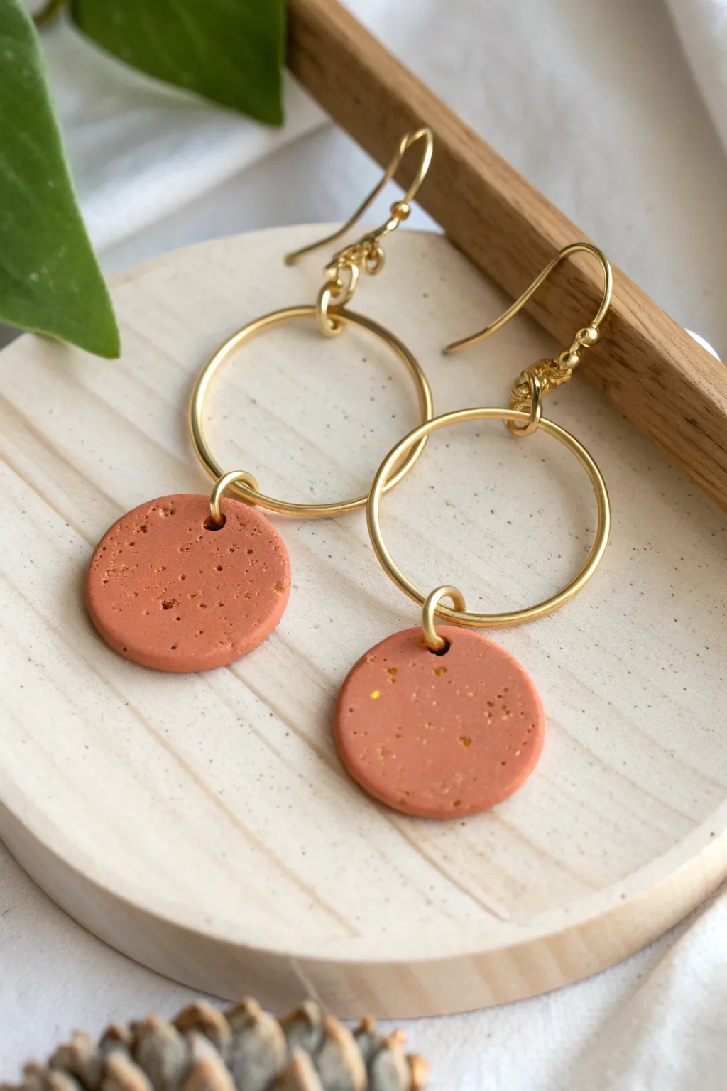 Minimal hoop earrings with bold clay disc charms for an easy, modern boho statement.