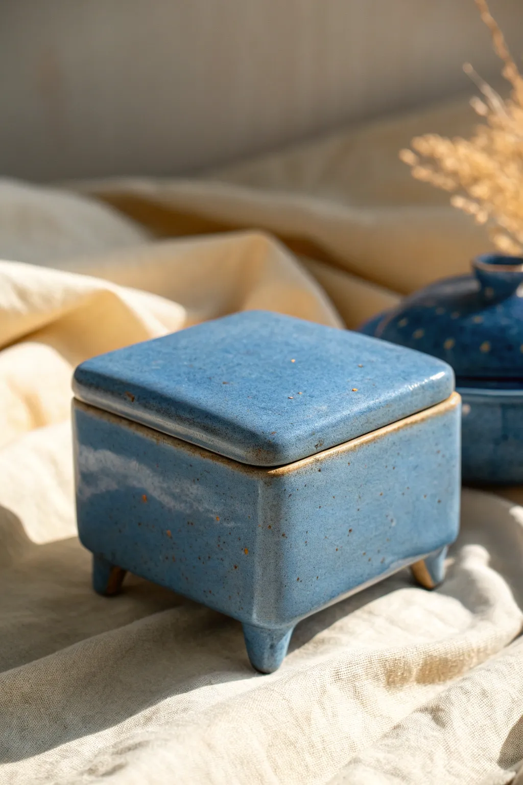 Footed slab box on tiny corner feet, bold matte glaze and soft shadow for airy lift