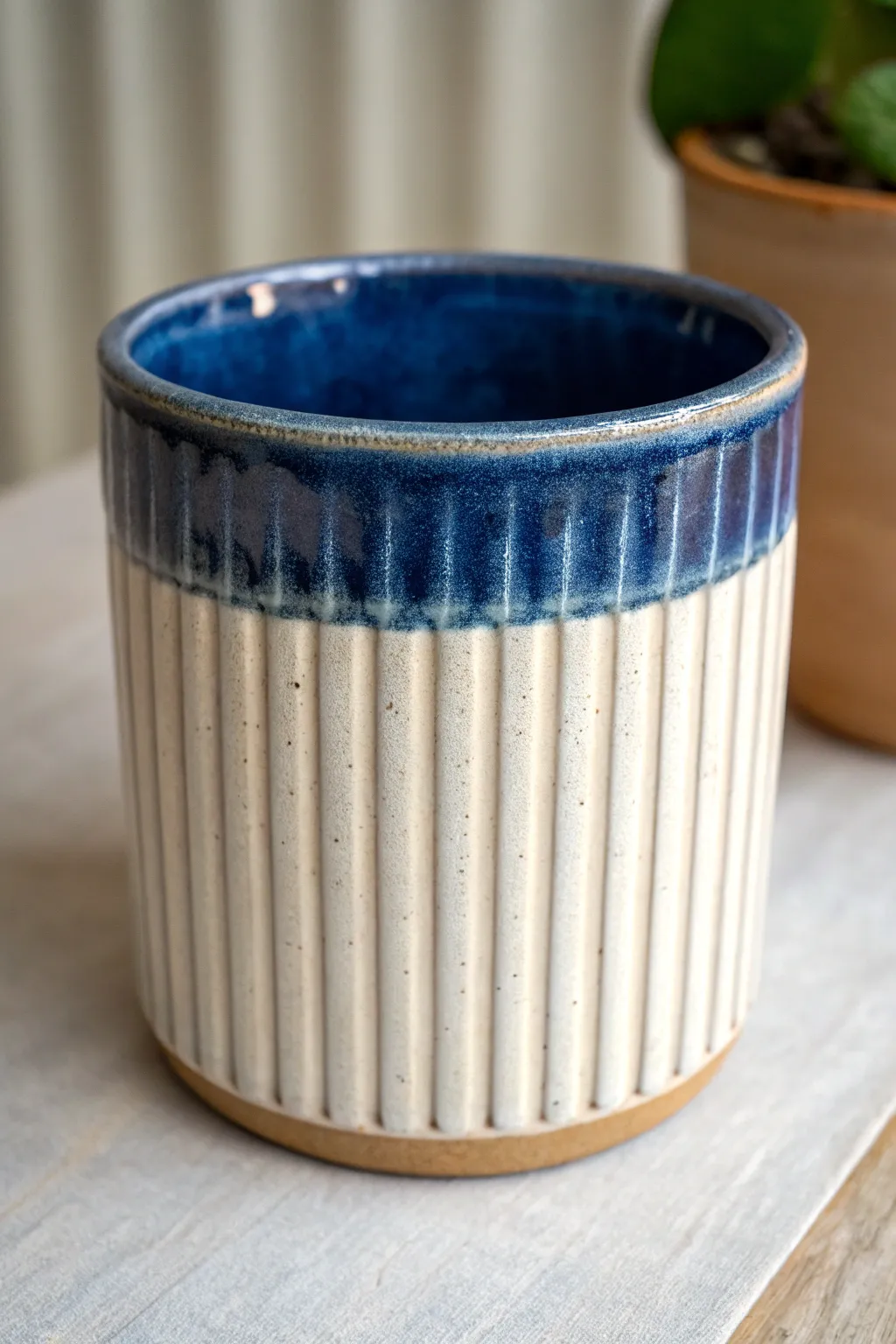 Ribbed slab container with bold glaze breaking over texture for a minimalist boho shelf.